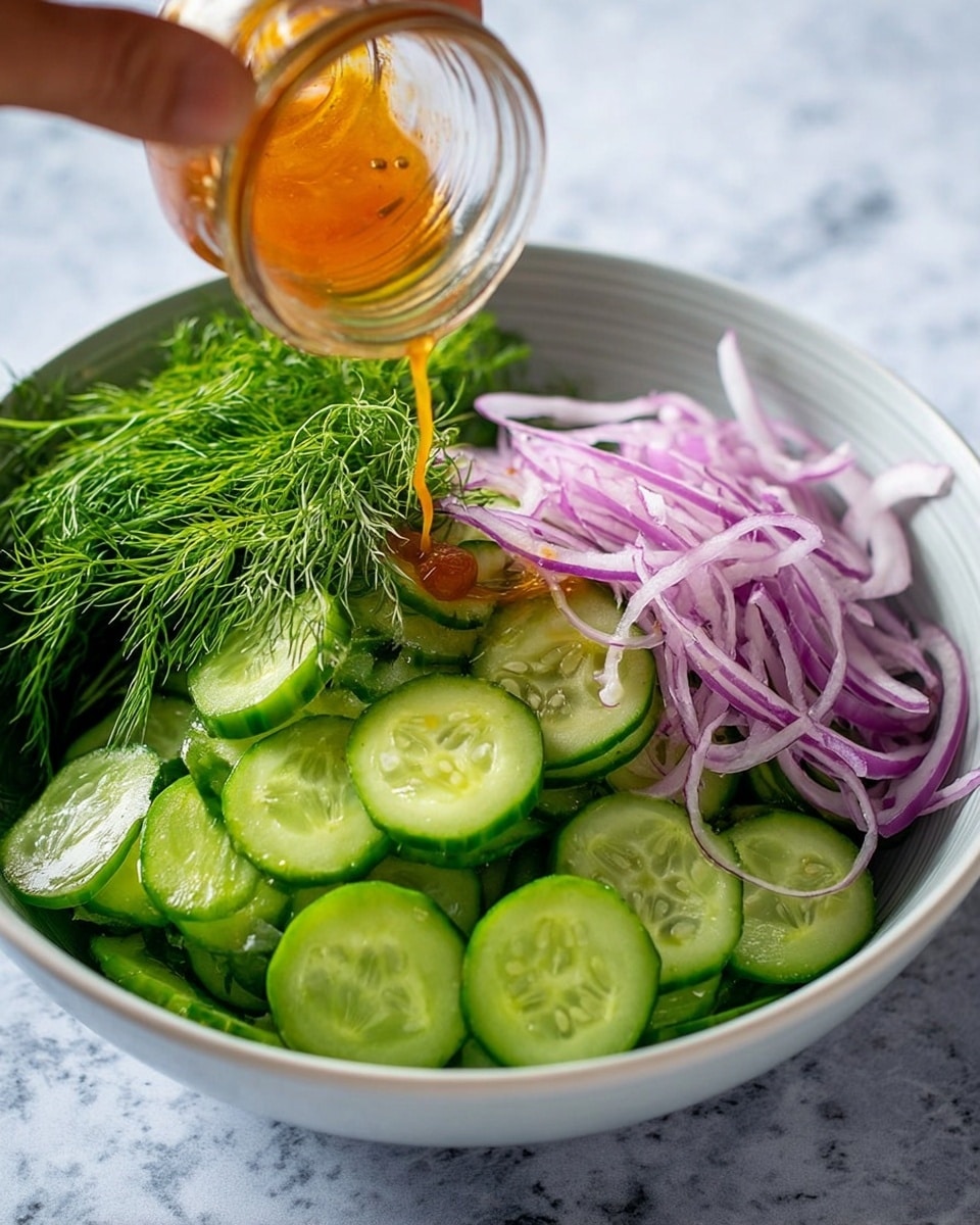 A white bowl filled with thinly sliced cucumber rounds forming the bottom and largest layer, bright green with visible seeds and watery texture. On one side, there is a bunch of fresh dill with feathery dark green leaves. Across from the dill, a layer of thin purple-red onion slices is placed in a small pile. A woman's hand is pouring a golden-orange dressing from a small glass bottle over the onion and cucumber layers. The bowl sits on a white marbled surface. photo taken with an iphone --ar 4:5 --v 7