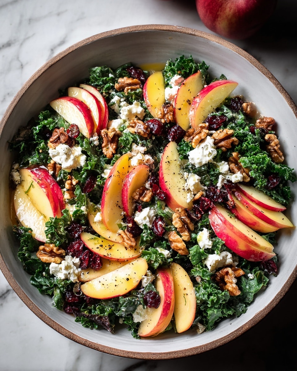A rustic white bowl filled with a vibrant salad sits on a white marbled texture. The base layer is dark green leafy kale, roughly chopped and spread evenly. Thin, crescent-shaped slices of red and yellow apples are scattered evenly on top, adding a fresh, light contrast. Small chunks of white cheese are sprinkled throughout, creating bright spots against the greens. Walnuts add a rich brown tone, placed generously around the salad for texture. Dried red cranberries add a splash of deep red, and the whole salad is drizzled with a glossy dressing that glistens under the light. The salad is finished with a sprinkle of black pepper, making the colors pop vividly. Photo taken with an iphone --ar 4:5 --v 7