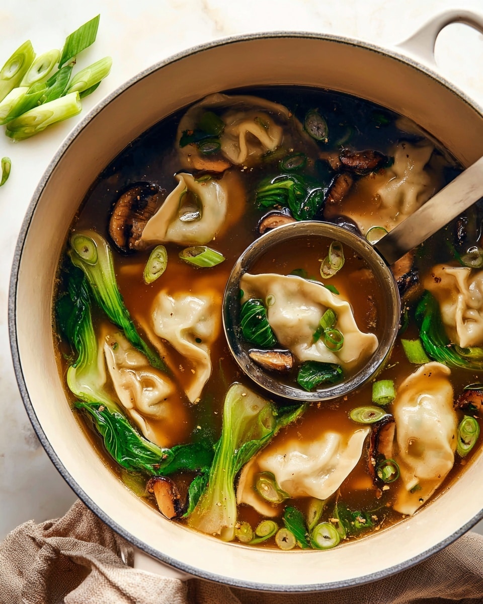 A large white pot filled with clear brown broth containing several dumplings with light beige, soft, and slightly wrinkled skins floating on the surface. Bright green baby bok choy leaves and stems, along with sliced shiitake mushrooms showing dark brown tops and lighter undersides, are scattered throughout the broth. Small rings of light green scallions float on top, adding color contrast. A silver ladle dips into the soup, partially lifted with a piece of bok choy and a dumpling resting in it. The pot sits on a white marbled surface with a small pile of sliced green scallions beside it, and a soft brown cloth partially visible near the base. The lighting highlights the textures of the dumplings, vegetables, and broth, making the soup look warm and fresh. Photo taken with an iphone --ar 4:5 --v 7