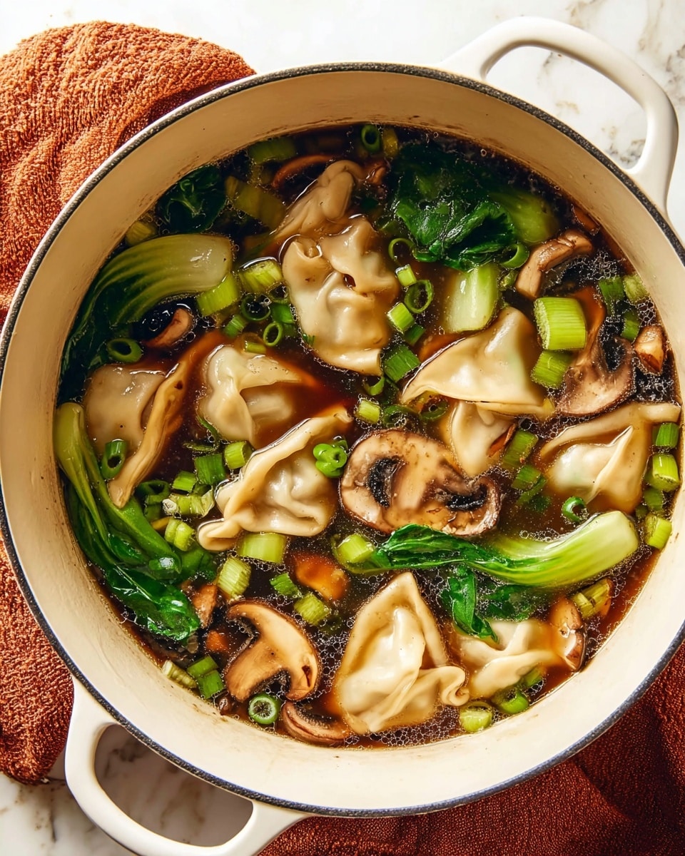A white pot filled with a clear dark brown broth containing several folded dumplings that are pale beige with a soft texture, scattered bright green sliced scallions, green bok choy leaves with a crisp texture, and sliced brown shiitake mushrooms with visible gills. The ingredients float evenly on the broth's surface, which has small bubbles and a slight oily sheen. The pot rests on a rust-colored cloth, and the background is a white marbled texture. photo taken with an iphone --ar 4:5 --v 7