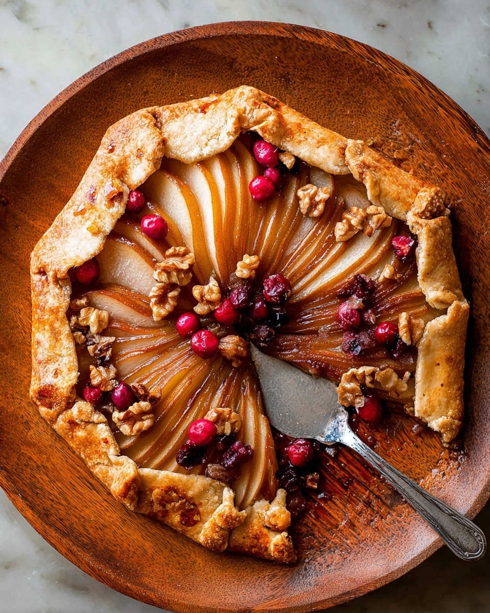A rustic galette with a single crust that is golden brown and flaky, folded unevenly around the edge. Inside, there are five slices of pear arranged in a fan shape, with a shiny caramelized brown color and soft texture. Scattered on top are bright red cranberries and whole walnuts, adding bursts of color and rough texture against the smooth pears. The galette sits in a round wooden dish with a metal serving spatula placed on the bottom right, partially under one of the pear slices. The background is a white marbled texture. Photo taken with an iphone --ar 4:5 --v 7