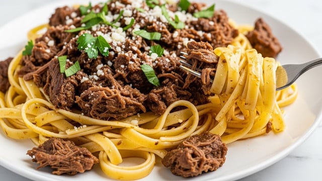 A close-up view of a plate filled with wide fettuccine pasta mixed with dark brown shredded beef pieces evenly spread throughout the dish. The pasta noodles have a shiny, golden-yellow color and are coated lightly with sauce. Fresh green herb leaves are scattered on top, adding a pop of color. Grated white cheese is sprinkled lightly over the whole dish. A silver fork is holding a twirl of noodles with beef close to the right side of the plate. The plate is white and set on a white marbled surface. Photo taken with an iphone --ar 4:5 --v 7